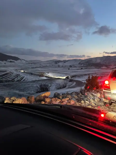 Pogled iz vozila na zimsku kolonu pred zalazak sunca