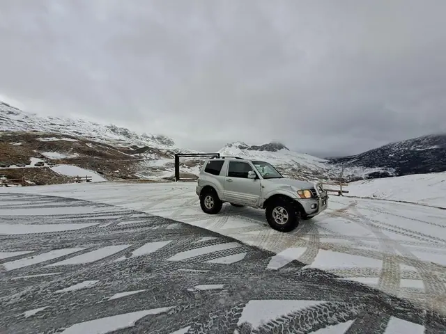 Srebrni terenac na zaleđenoj površini pored planinskog puta
