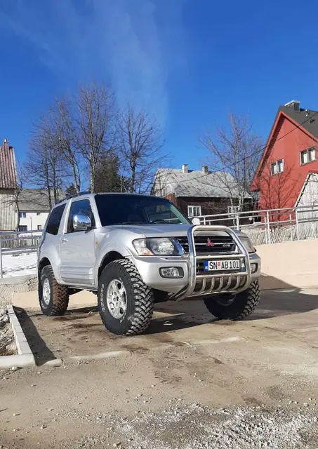 Srebrni terenac parkiran u naselju pod vedrim nebom