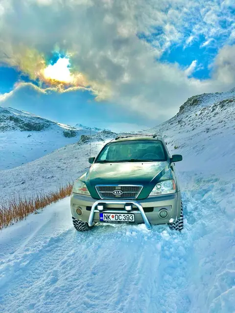 Terenac na snijegu ispod planinskih vrhova